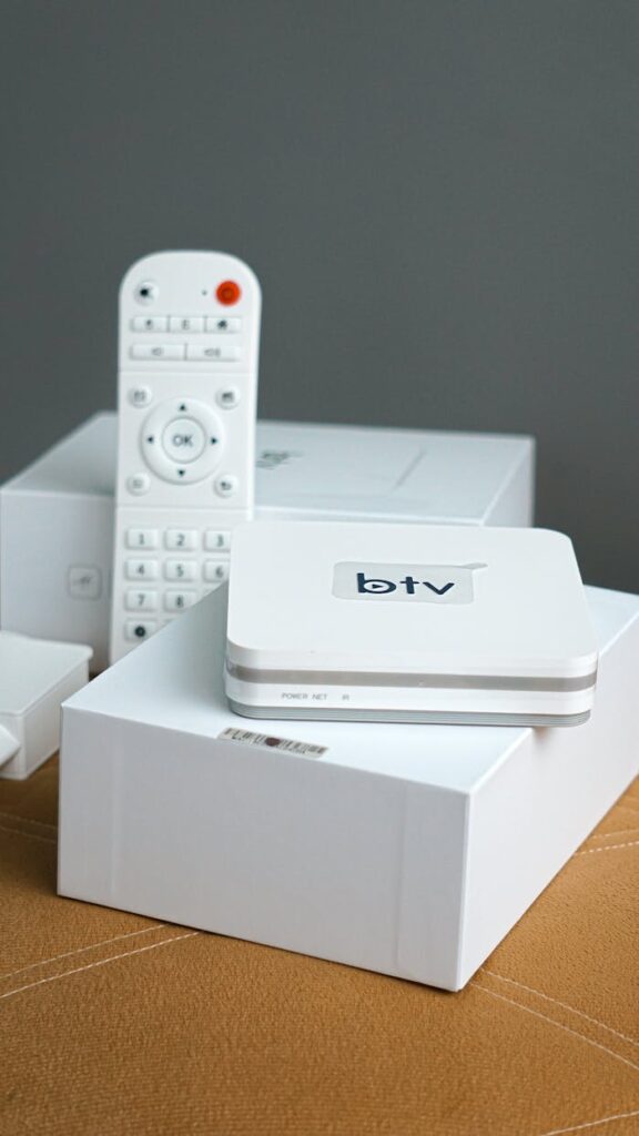 pexels-photo-11031497 Vertical shot of a modern smart TV setup including a remote control and electronic device.